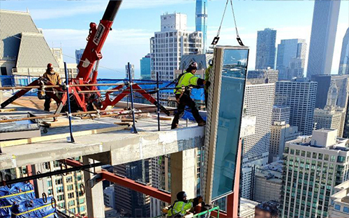 Glass being installed at the top of the One Chicago building.