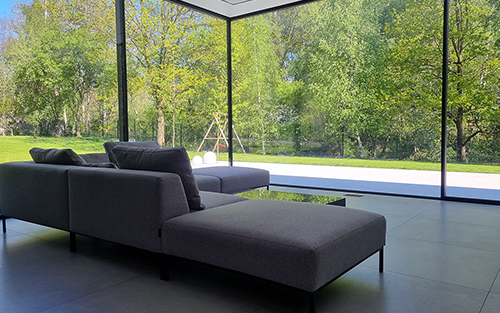 Inside view of a modern home with floor to ceiling glass windows.