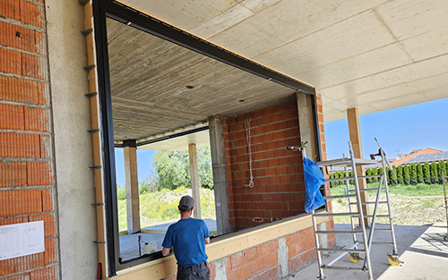 A Startesta worker installing glass windows of a commercial building.