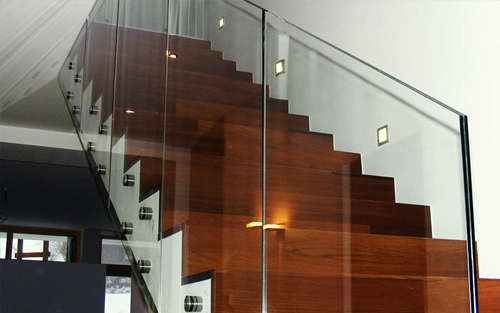 A wood and glass modern staircase in a home.